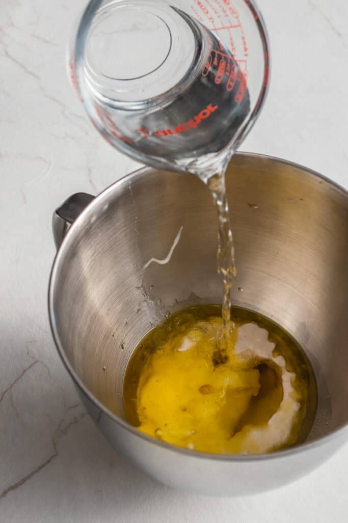 Water poured into a stand mixer bowl with oil. 