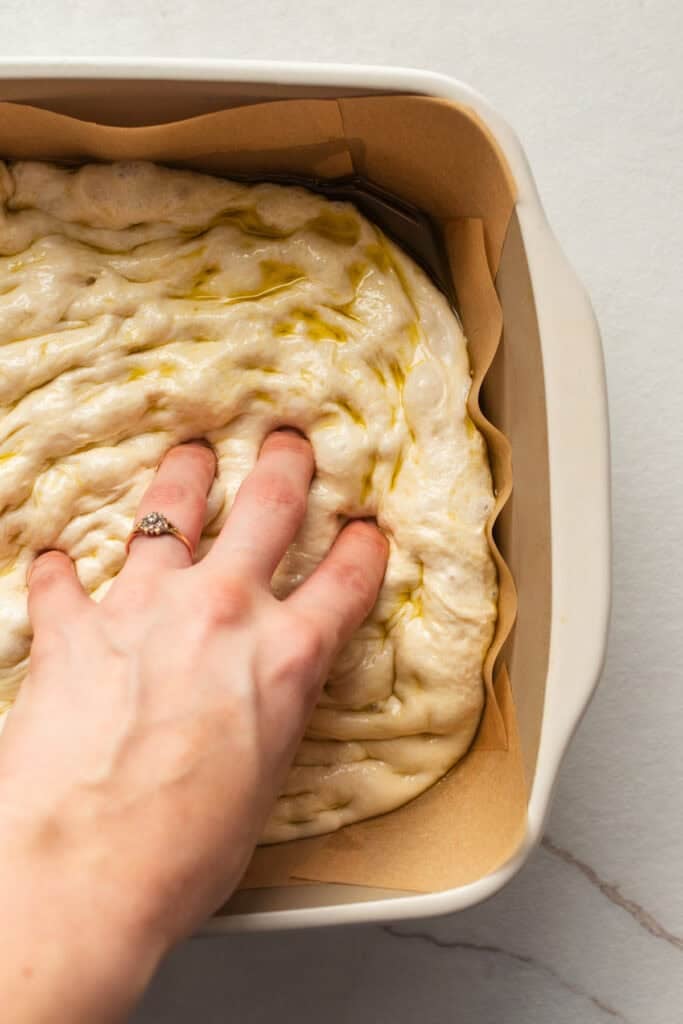 Dough pressed into a parchment paper lined baking dish. 