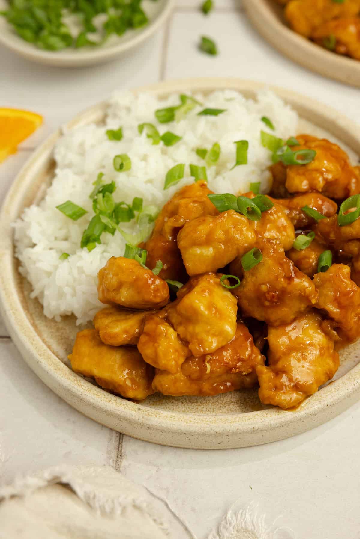 A plate of orange chicken with rice.