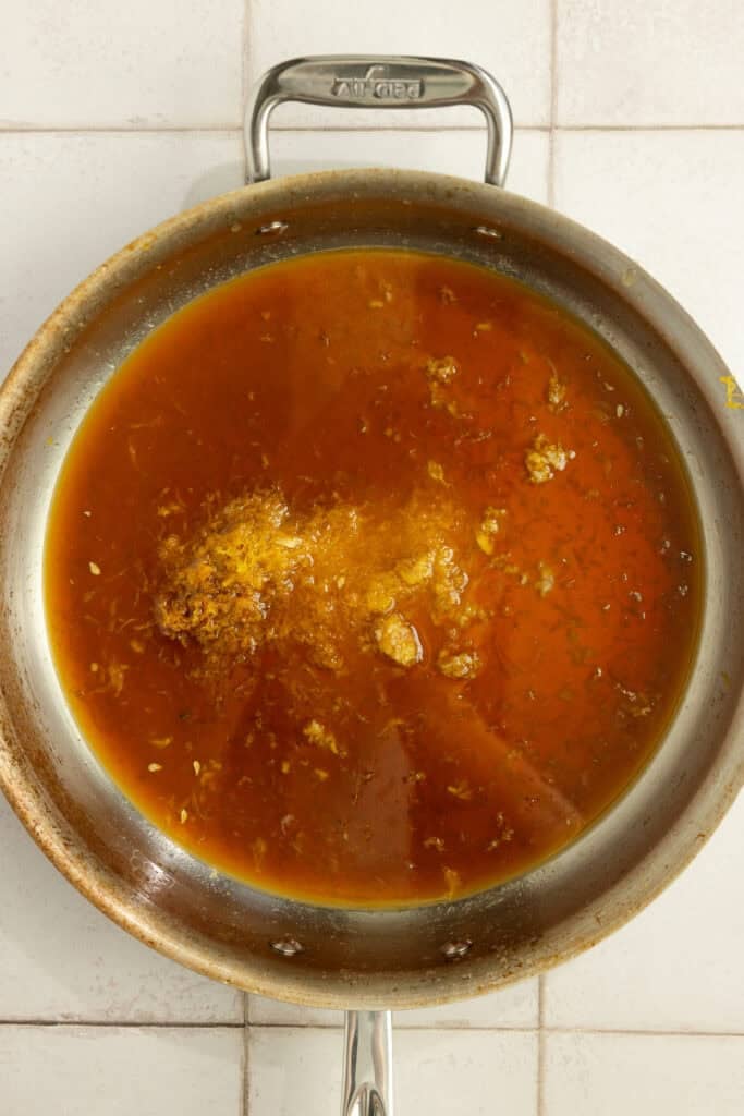 A saucepan with ingredients for an orange sauce. 