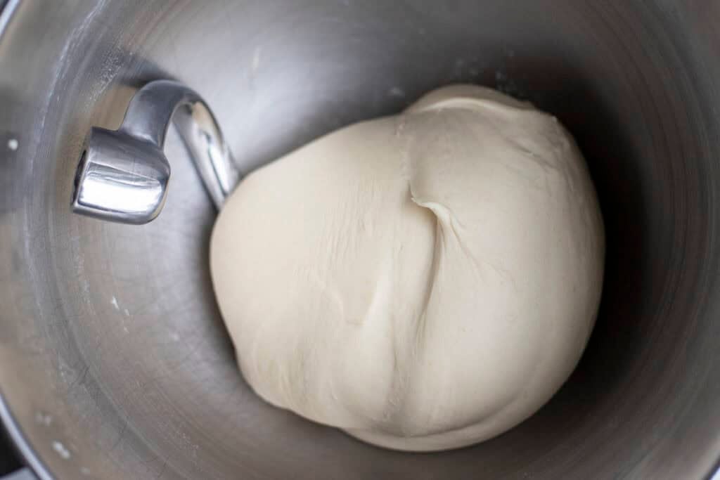 Pizza dough in a stand mixer.