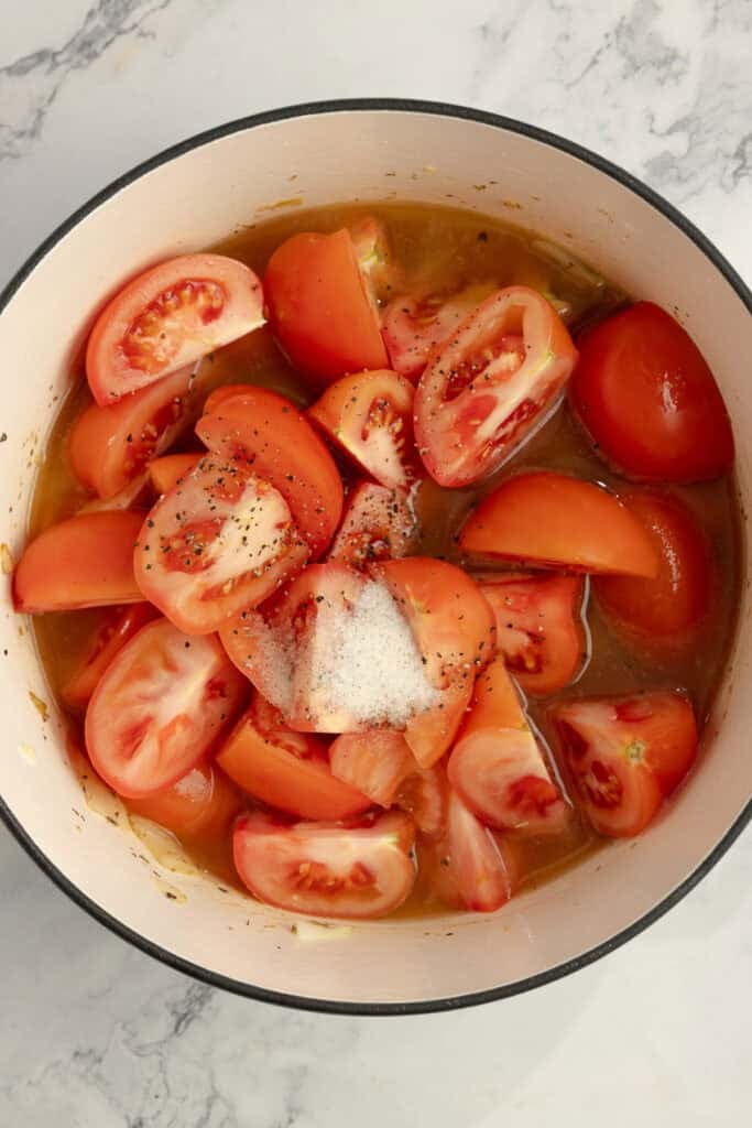 Chopped tomatoes added to a dutch oven. 