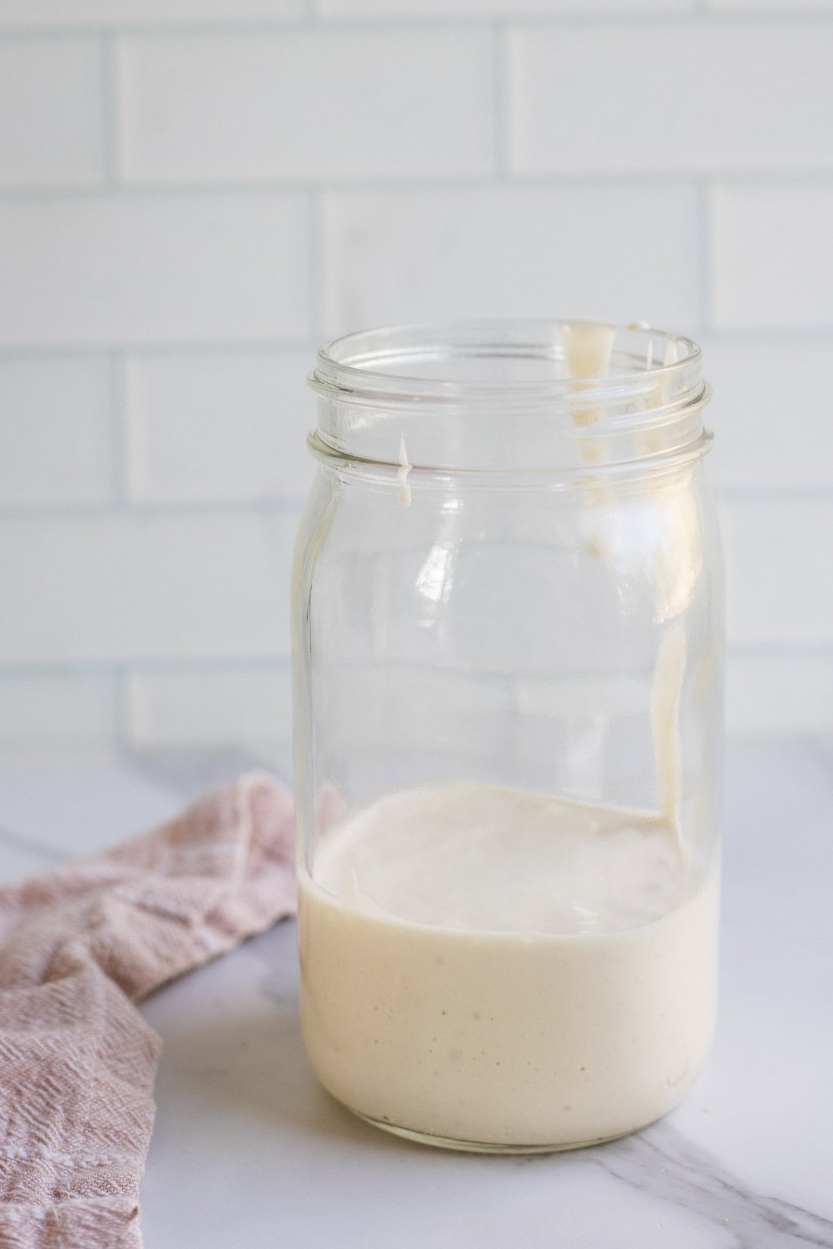 A large mason jar half filled with sourdough discard.