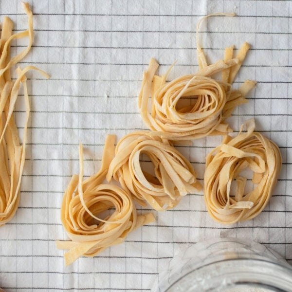 Rolls of pasta on a striped tea towel.